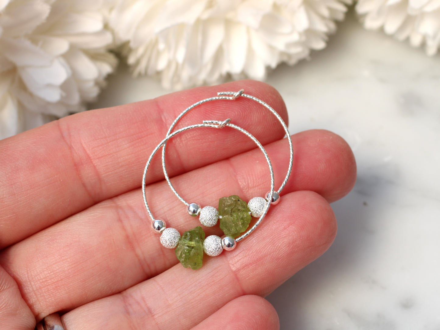 Peridot hoop earrings in silver.