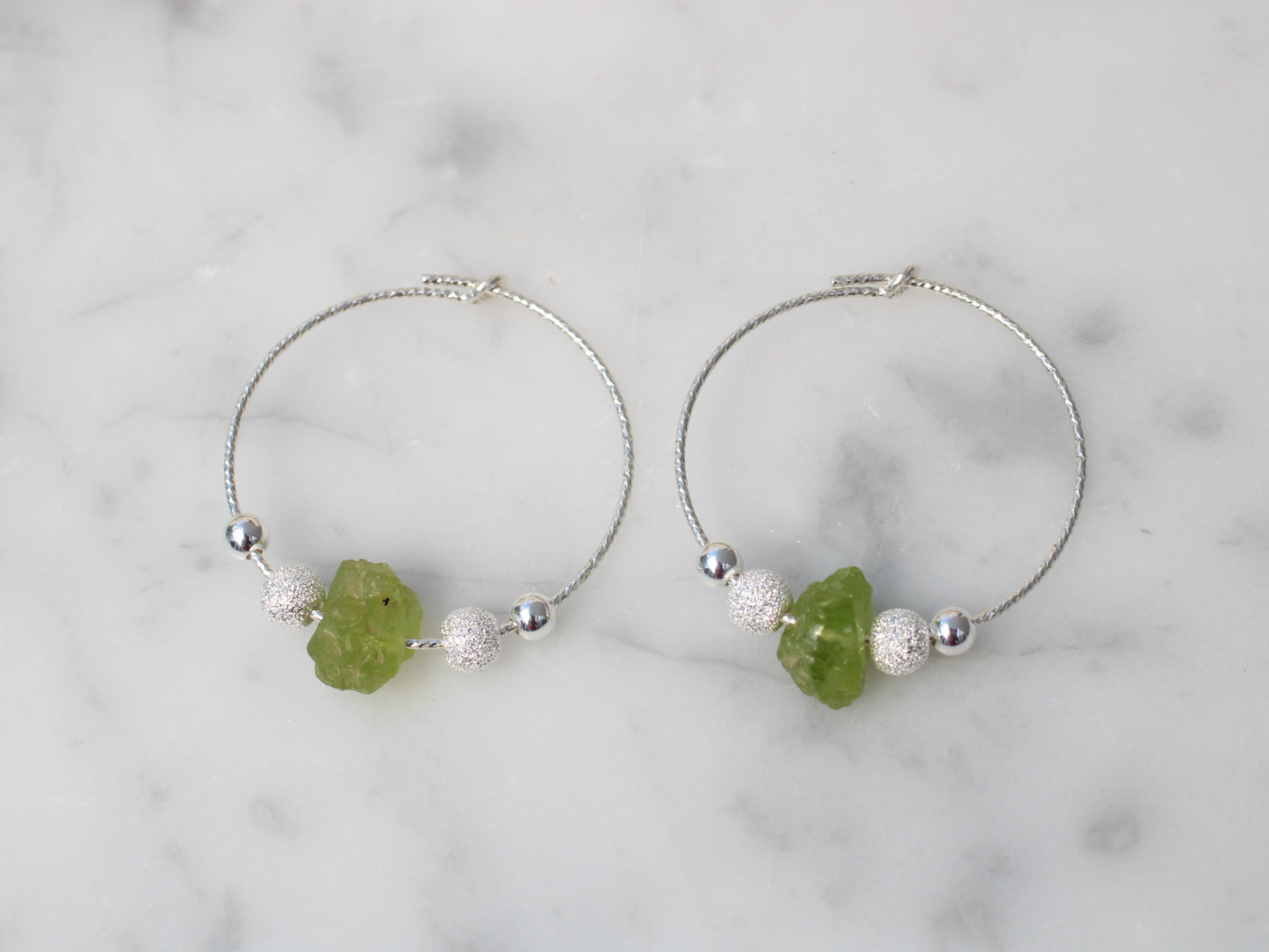 Peridot hoop earrings in silver.