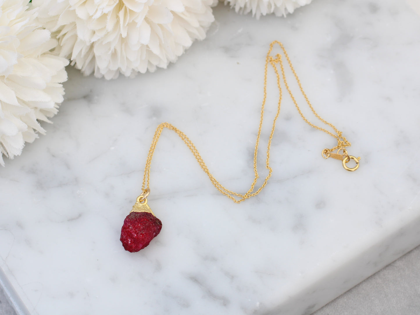 Raw ruby necklace in gold.