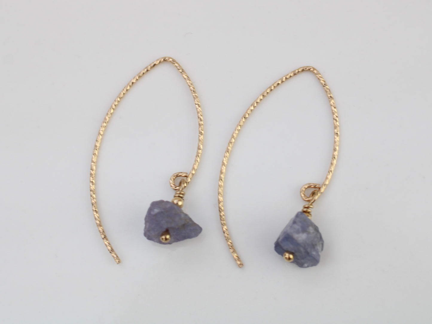 Raw tanzanite earrings in gold.