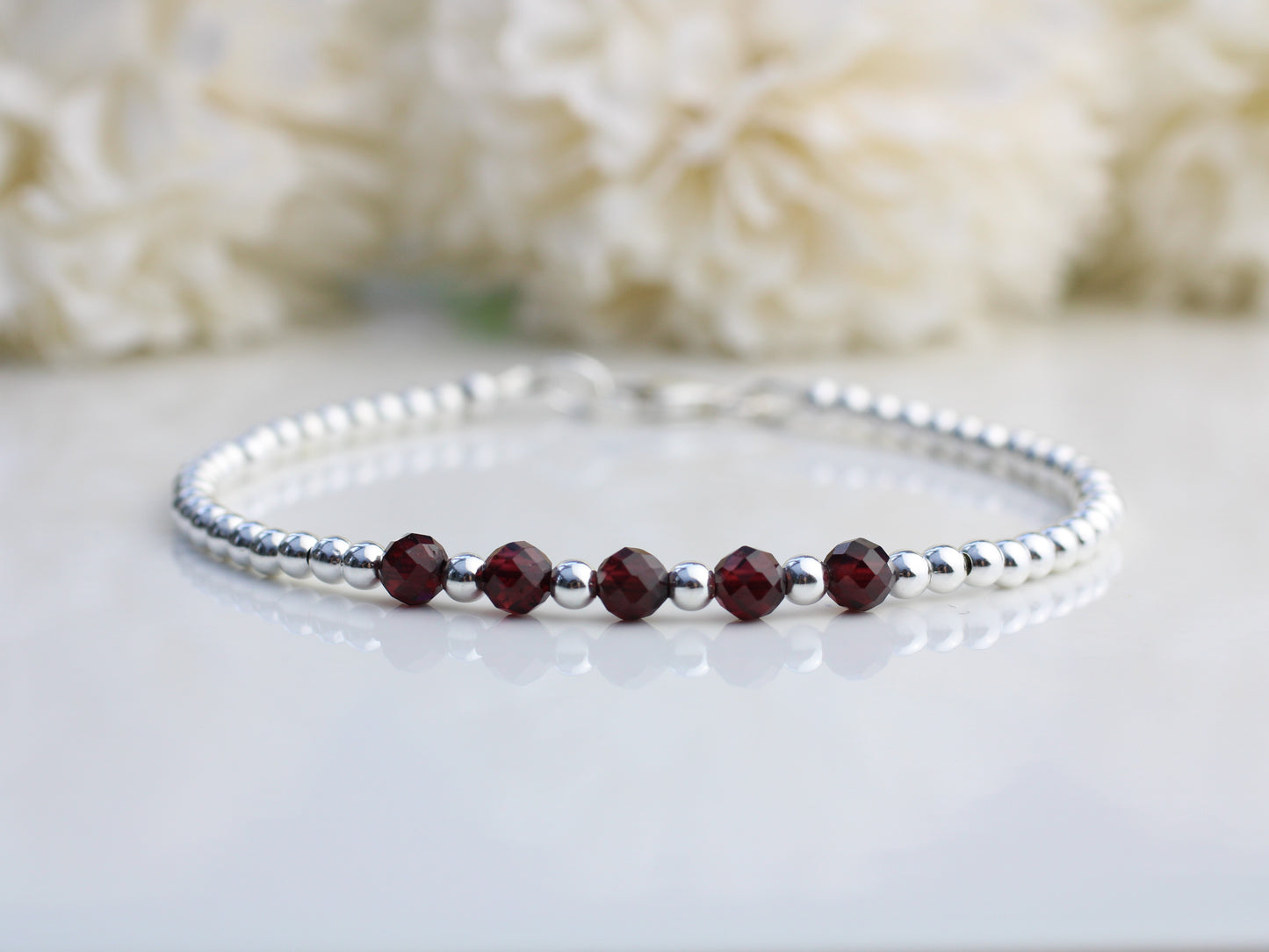 Garnet milestone bracelet in sterling silver.