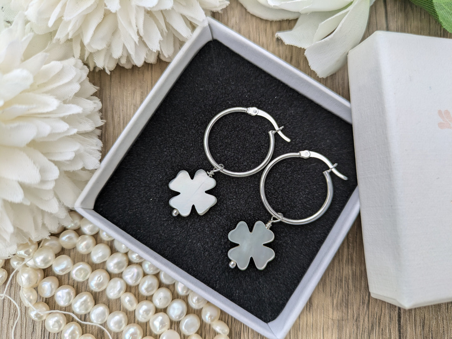 Four leaf clover hoop earrings in silver.