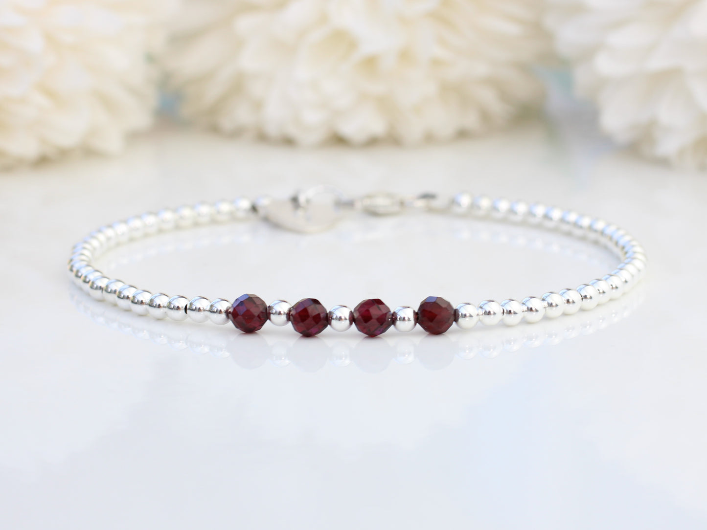 Garnet milestone bracelet in sterling silver.