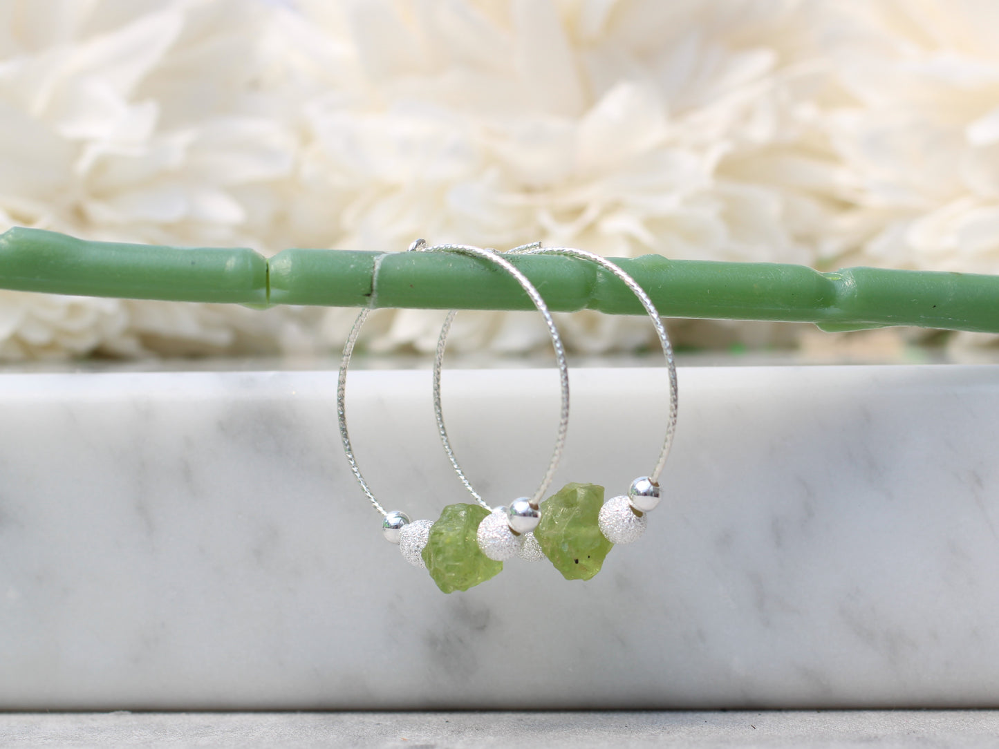 Peridot hoop earrings in silver.